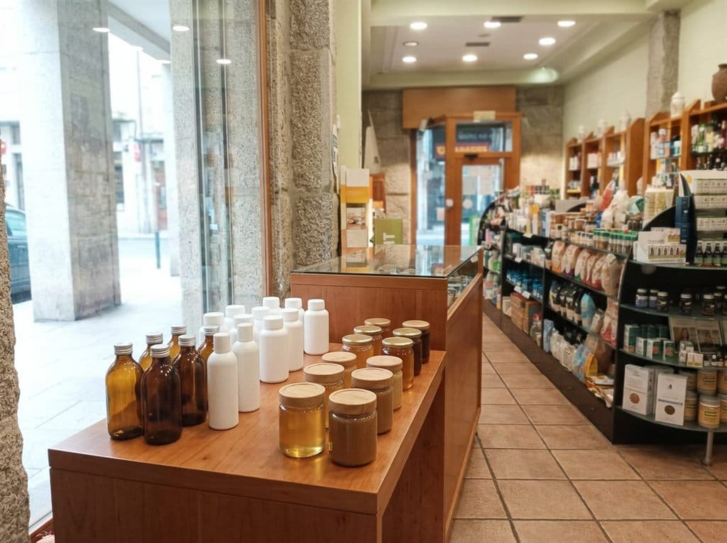 Mesa expositora con vitaminas, minerales, miel y própolis en herbolario de Ourense